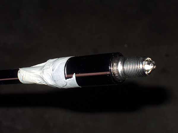 Spark plug with adhesive tape